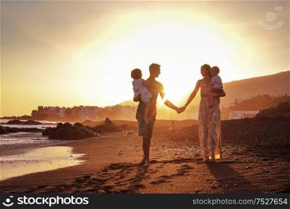 Relaxed family on a tropical beach, beautiful sunset