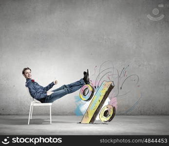 Relaxed guy. Young man sitting in chair with legs up and relaxing