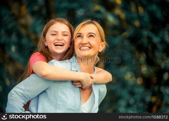 Relaxed happy mother and little kid daughter in outdoors public park. Parenthood and child concept.