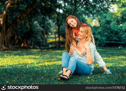 Relaxed happy mother and little kid daughter in outdoors public park. Parenthood and child concept.