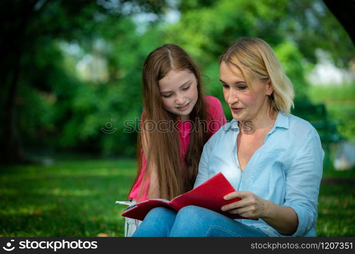 Relaxed happy mother and little kid daughter in outdoors public park. Parenthood and child concept.. Happy mother and little kid daughter in park.