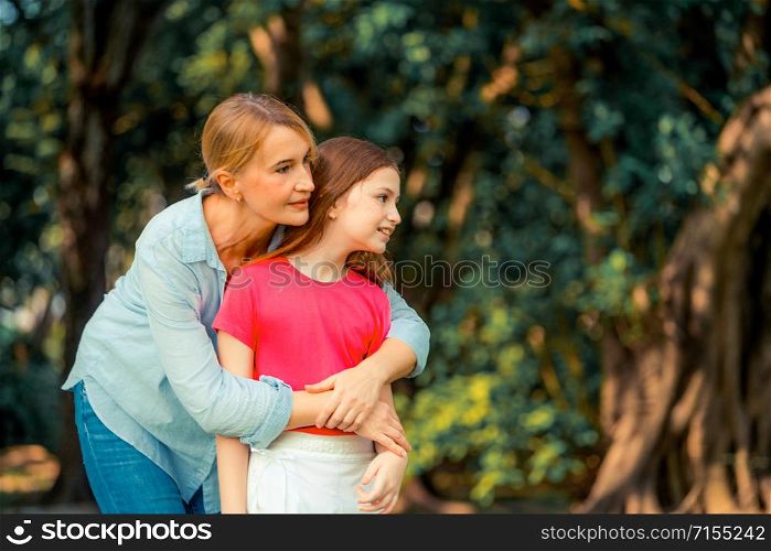 Relaxed happy mother and little kid daughter in outdoors public park. Parenthood and child concept.