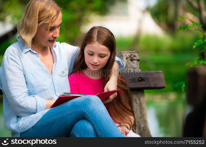 Relaxed happy mother and little kid daughter in outdoors public park. Parenthood and child concept.