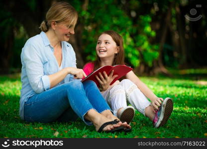 Relaxed happy mother and little kid daughter in outdoors public park. Parenthood and child concept.