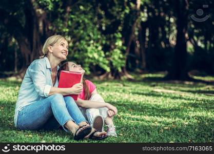Relaxed happy mother and little kid daughter in outdoors public park. Parenthood and child concept.