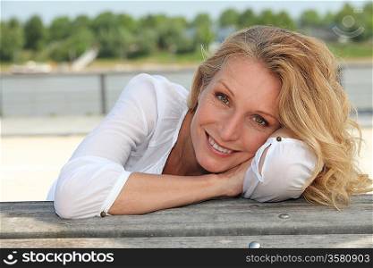 Relaxed happy woman sitting on the waterfront