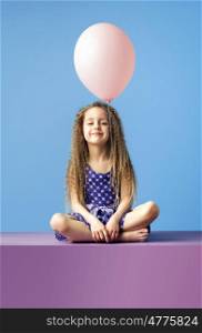 Relaxed little girl holding a balloon