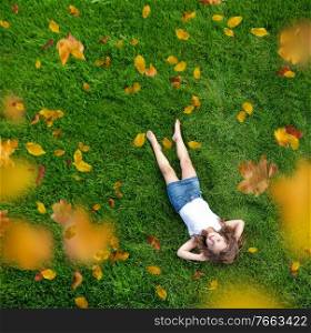Relaxed little girl lying on a fresh, green meadow