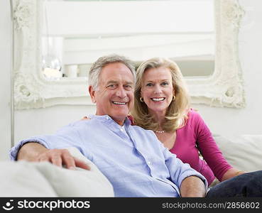 Relaxed portrait of successful mature couple in white home interior