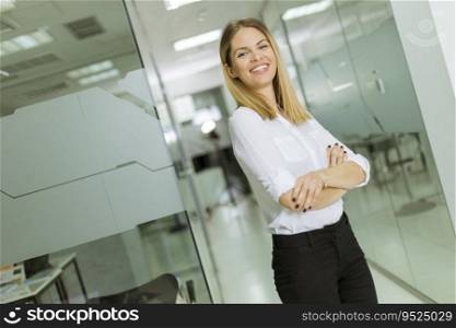 Relaxed pretty confident young businesswoman standing standing in the modern office