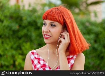 Relaxed red haired woman listening music in a park