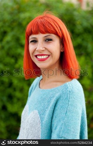 Relaxed red haired woman with blue jersey in the park