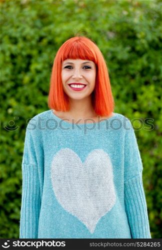 Relaxed red haired woman with blue jersey in the park