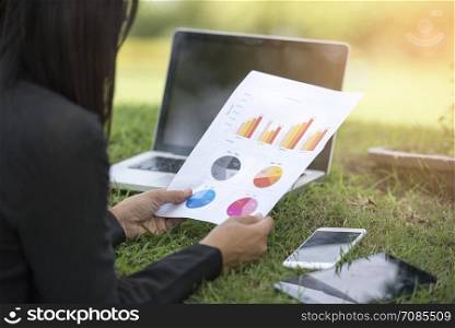 Relaxed Sales Managers Working Outdoor. Working Woman Showing Hand Market Report Charts.Planning New Strategy.Prepare Business Document. Using Marketing Plans, Sales Reports. Horizontal, Film Effect