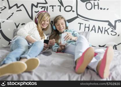 Relaxed sisters listening to music at home