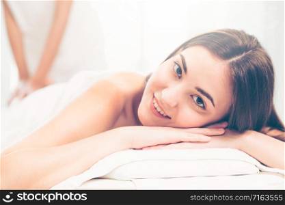Relaxed woman getting back massage in luxury spa with professional massage therapist in background. Wellness, healing and relaxation concept.. Woman gets back massage spa by massage therapist.