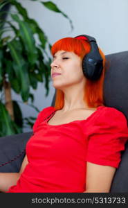 Relaxed woman in red listening music at home