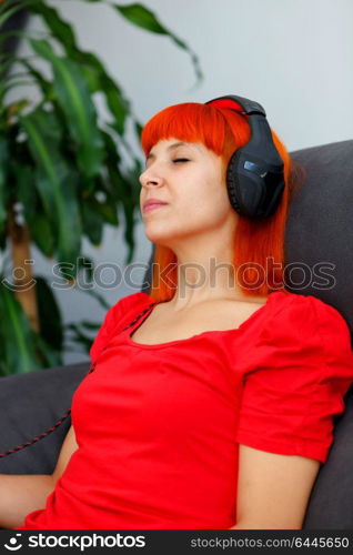 Relaxed woman in red listening music at home