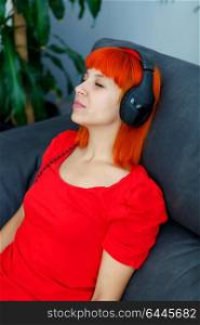Relaxed woman in red listening music at home
