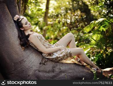 Relaxed woman laying on the giant tropical tree