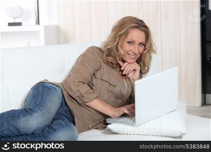Relaxed woman using a laptop computer on her sofa