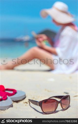 Relaxed woman using a smartphone on a tropical beach