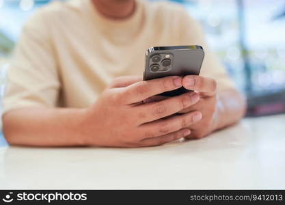 Relaxed young asian man using smart phone  spending time checking news social media