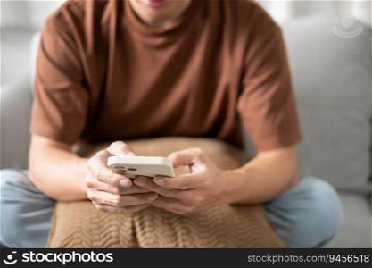 Relaxed young asian man using smart phone  spending time checking news social media.
