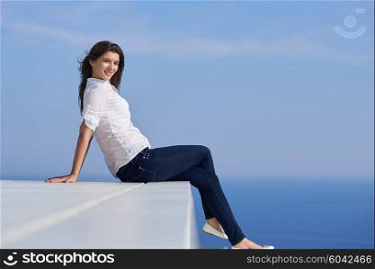 relaxed young beautiful woman in front of luxury modern home villa on balcony on sunny day