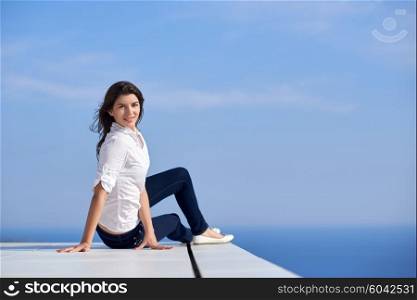 relaxed young beautiful woman in front of luxury modern home villa on balcony on sunny day