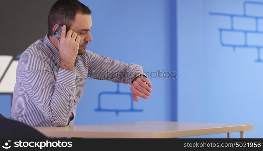 relaxed young businessman using smart phone at modern startup business office