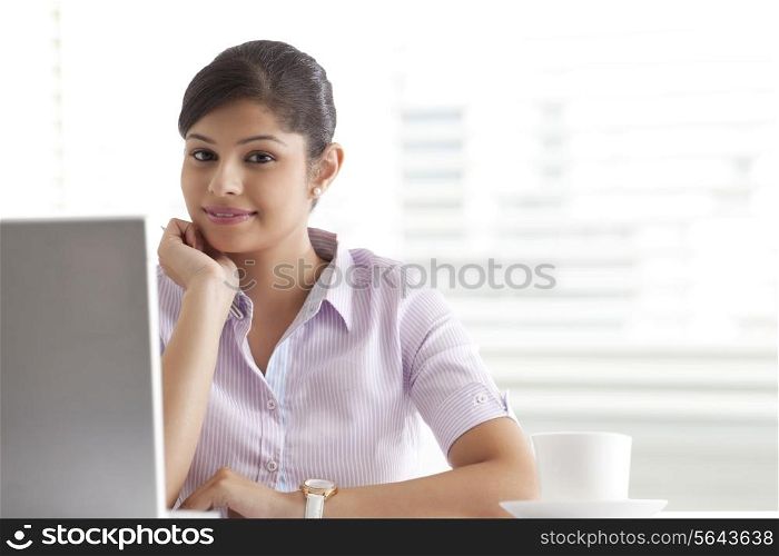 Relaxed young businesswoman sitting at her desk