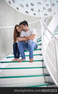 relaxed young couple on spiral glass stairs in modern home villa indoors