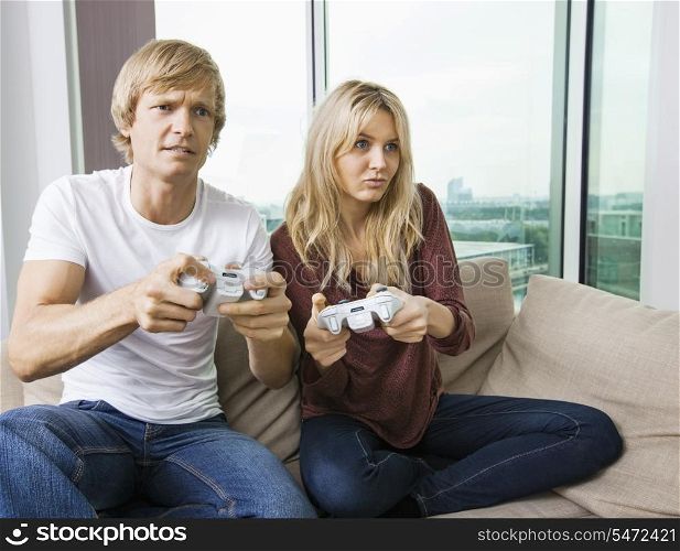 Relaxed young couple playing video game in living room at home