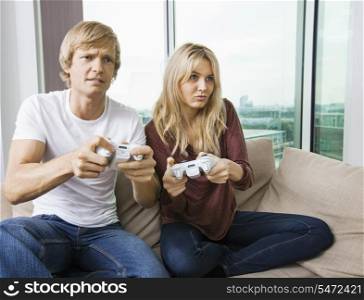 Relaxed young couple playing video game in living room at home