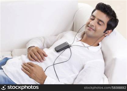 Relaxed young man listening music through cell phone