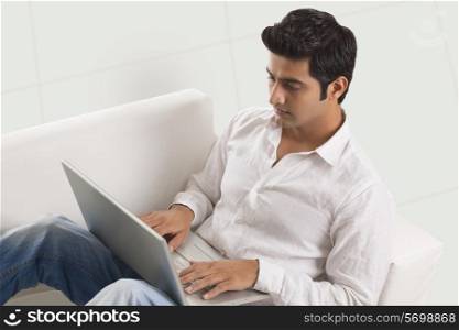 Relaxed young man working on laptop