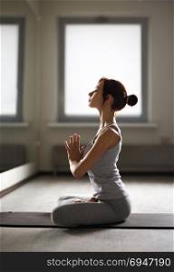 Relaxed young sportswoman doing yoga and meditating in studio. Relaxed young sportswoman doing yoga and meditating in studio.