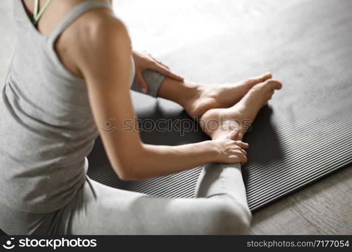 Relaxed young sportswoman doing yoga and meditating in studio.. Relaxed young sportswoman doing yoga and meditating in studio