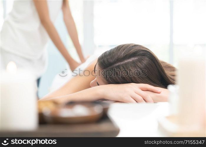 Relaxed young woman at the luxury wellness spa.. Woman gets back massage spa by massage therapist.