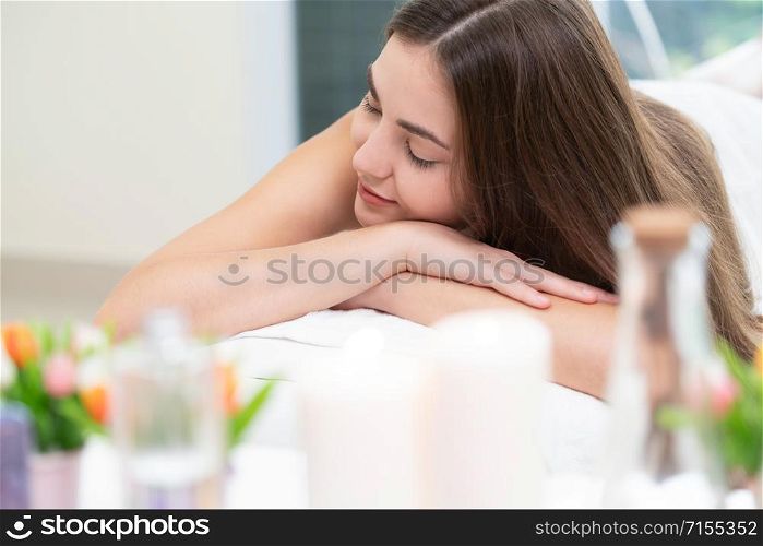 Relaxed young woman at the luxury wellness spa.. Woman lying on spa bed for massage in luxury spa.