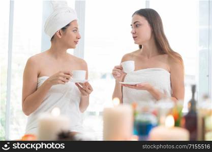 Relaxed young woman at the luxury wellness spa.. Two women drinking tea in luxury day spa.