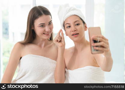 Relaxed young woman at the luxury wellness spa.. Happy women takes selfie with mobile phone in spa.