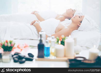 Relaxed young woman lying on spa bed prepared for facial treatment and massage in luxury spa resort. Wellness, stress relief and rejuvenation concept.