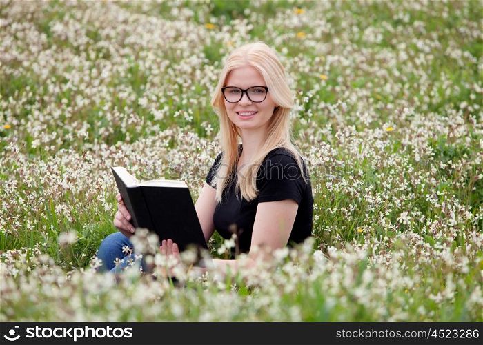 Relaxed young woman reading a book on nature