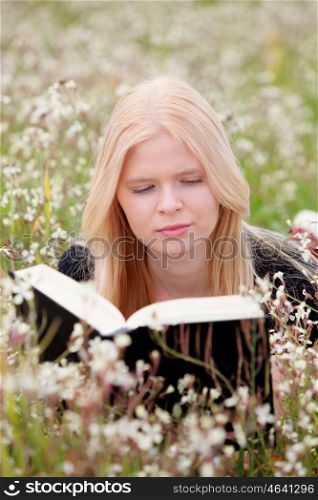 Relaxed young woman reading a book on nature