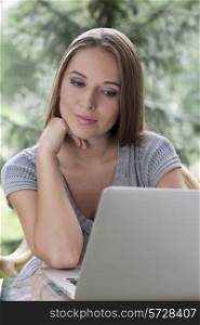Relaxed young woman using laptop outdoors