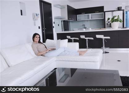 relaxed young woman working on laptop computer in bright home indoor
