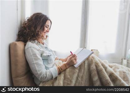 relaxed young woman writing her notebook
