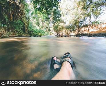 relaxing in nature concept from feet in refreshing natural water stream.